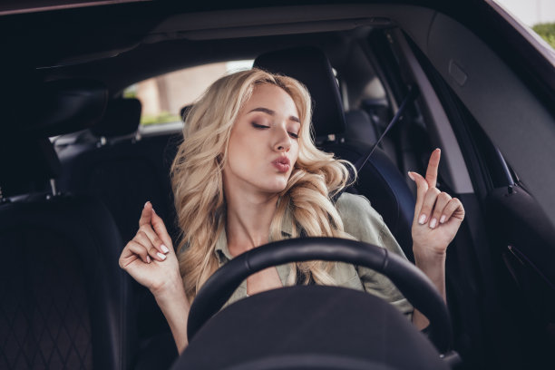 相当积极兴奋的女孩肖像驾驶汽车坐在前排手指享受播放列表图片下载
