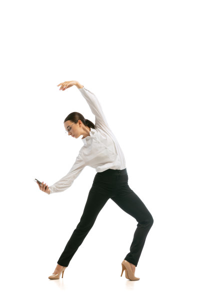 美丽的年轻女孩穿着商务风格的服装跳跃和舞蹈孤立在白色背景。创业、创业、开放空间、专业的职业理念。图片下载