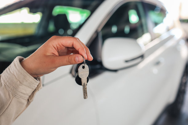 手里拿着钥匙，车停在停车场图片下载