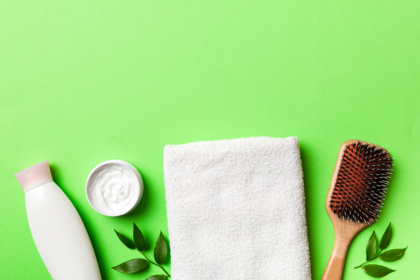 用于头发护理的化妆品，奶油和毛巾在彩色背景俯视图。平躺图片下载