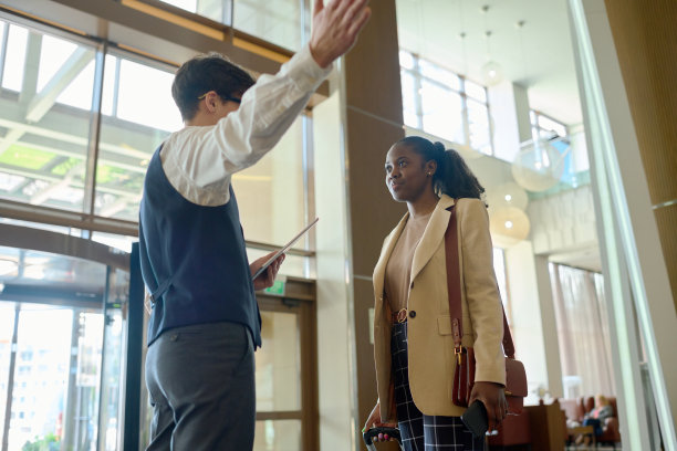 年轻的业主，豪华的现代酒店在休息室会见客人之一图片下载