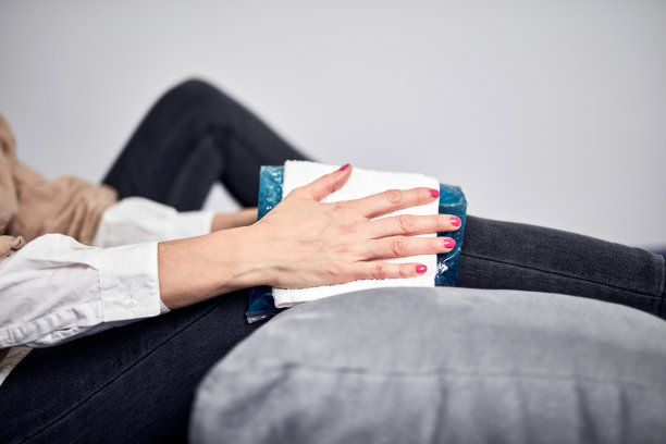 患有痉挛、抽筋、扭伤、膝关节脱位、肌腱断裂等关节疼痛的妇女，在家用冷敷胶包。图片下载