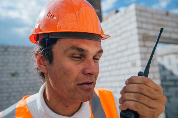 戴头盔的建筑工人在电台讲话图片下载