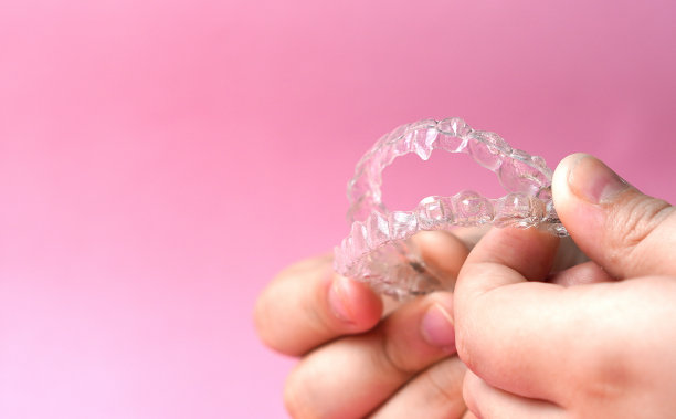 手握隐形支撑在粉红色的背景图片下载