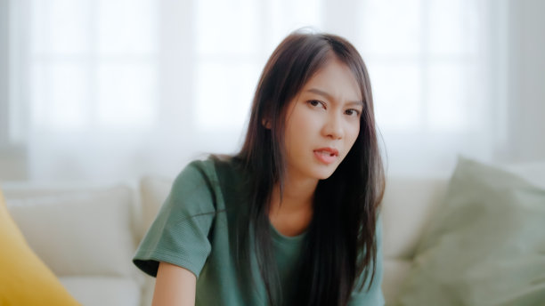 因工作或人际关系问题而沮丧的亚洲女性，坐在沙发上，感到绝望和焦虑，孤独，有心理问题图片下载