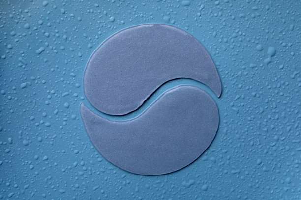 眼罩下，蓝色潮湿的背景，平躺着。美容产品图片下载