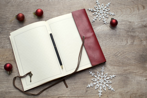 打开空白笔记本笔记与钢笔，圣诞球，雪花装饰在木制桌子上的拷贝空间。新年计划，决议背景图片下载