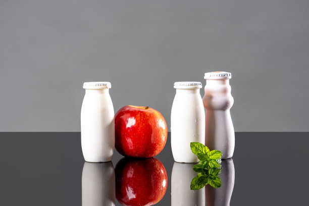 含有益生菌、双歧杆菌和维生素的乳制品。白色瓶装酸奶，苹果和薄荷作为益生菌食品的概念。双歧杆菌增加免疫力。益生菌促进消化。图片下载