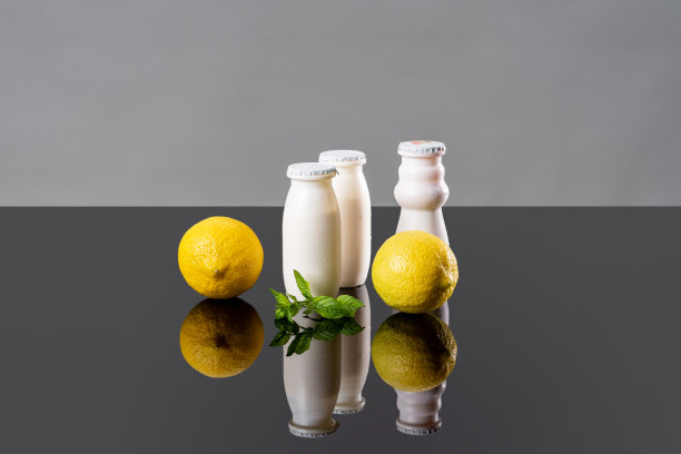 含有益生菌、双歧杆菌和维生素的乳制品。白瓶装酸奶和新鲜柠檬作为益生菌食品的概念。双歧杆菌增加免疫力。益生菌促进消化。图片下载