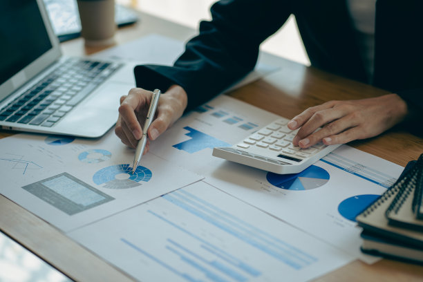 公司的会计分析了营业台上的费用。财务报表会计计算机与图表业务思想财务会计图片下载