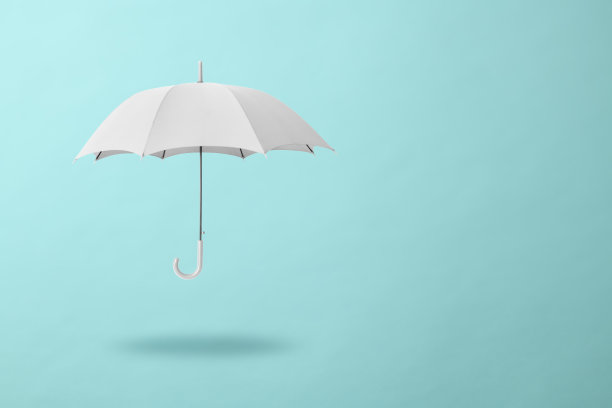 白色的伞在浅蓝色的背景下漂浮在半空中图片下载