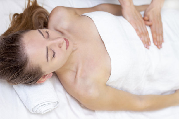 在温泉沙龙享受按摩的年轻女子。图片下载