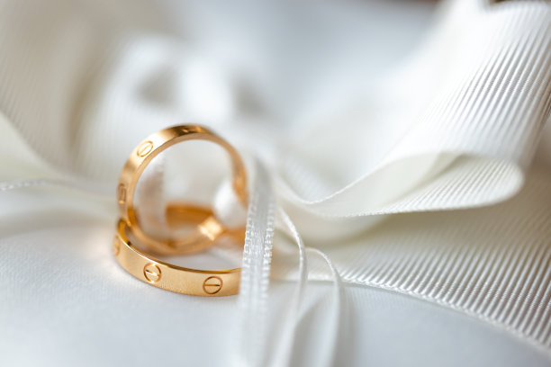 两个金色的结婚戒指在柔软的白色背景婚礼背景图片下载