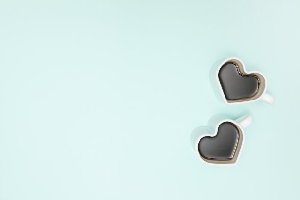 浅蓝色背景的心形咖啡杯。从以上观点。图片下载