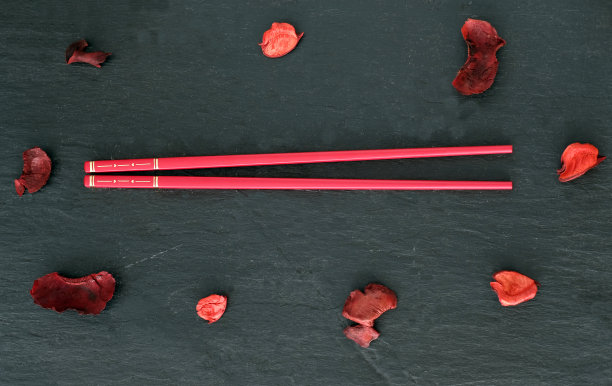 红筷子和花瓣在石灰色的背景-扁平图片下载