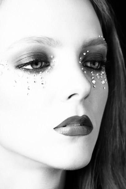 美丽的女人肖像与粘在她的脸上的珠宝图片下载