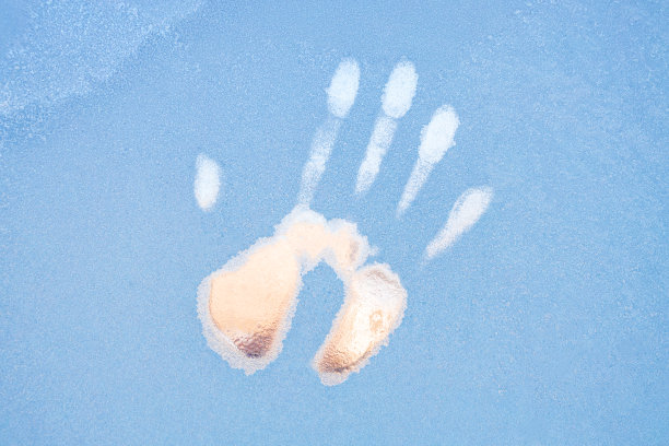 手印在玻璃上覆盖着白霜，右手掌心下有融化的冰印图片下载