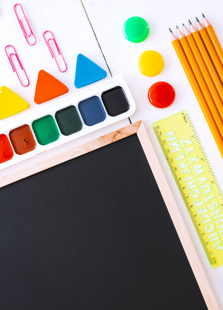 平铺文具粉笔板在一张白色背景的桌子上，打结。图片下载