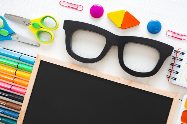 平铺文具粉笔板在一张白色背景的桌子上，打结。图片下载