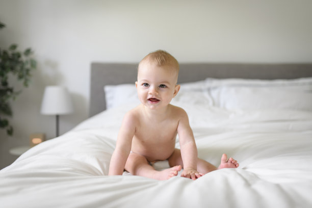 可爱的小男孩早上在家里白色阳光充足的卧室里图片下载