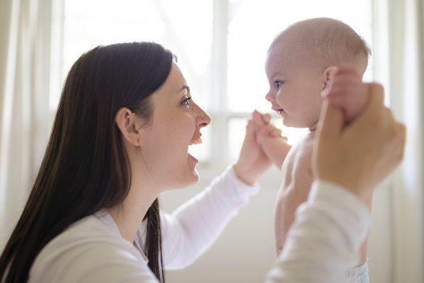 母亲和婴儿在家里的白色床上图片下载