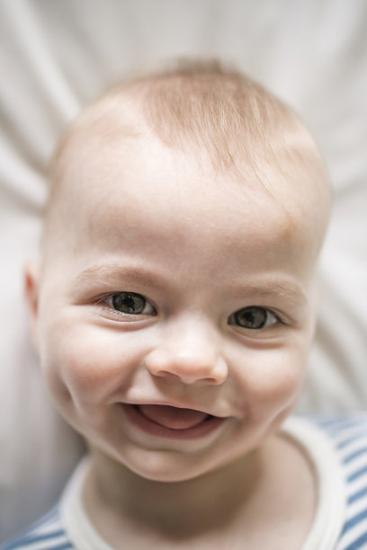 可爱的小男孩早上在家里白色阳光充足的卧室里图片下载