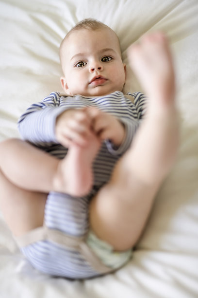 可爱的小男孩早上在家里白色阳光充足的卧室里图片下载