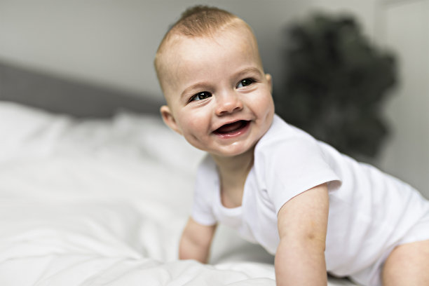 可爱的小男孩早上在家里白色阳光充足的卧室里图片下载