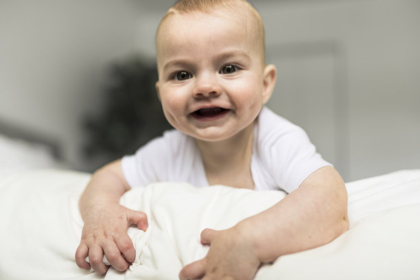 可爱的小男孩早上在家里白色阳光充足的卧室里图片下载