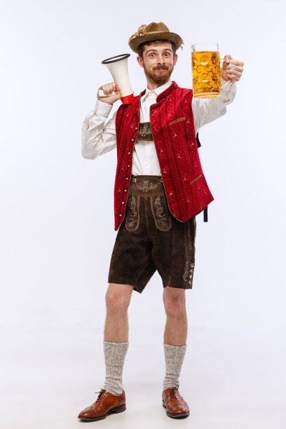 年轻富有表现力的男子戴着帽子，穿着传统的巴伐利亚或德国服装与大啤酒杯。酒精，传统，节日，啤酒节的概念。图片下载