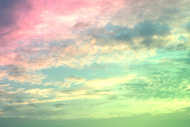 美丽甜美的粉色绿色彩色的蓬松的云在天空。多色彩虹图像。抽象幻想成长之光图片下载