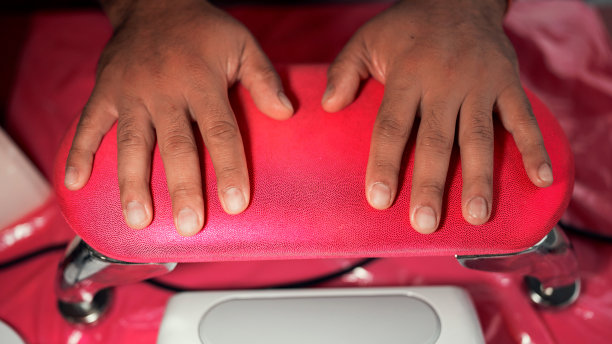 拉丁裔男性手放在手垫后，专业的美甲沙龙接近图片下载