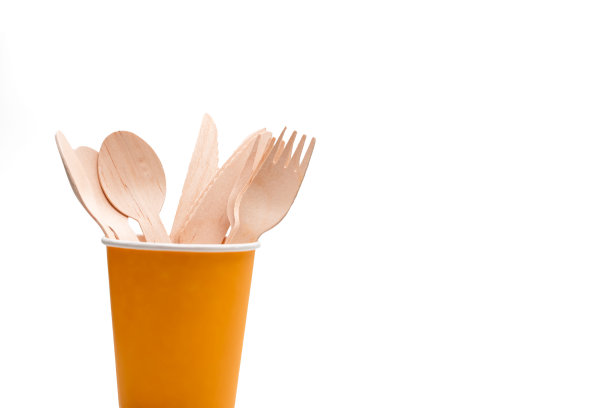 一次性黄色纸杯和木制餐具隔离。图片下载