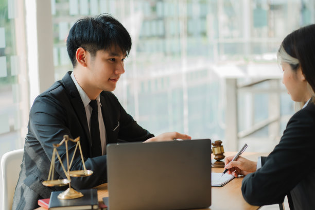 法律应该知道这个概念。律师会向客户解释如何策划法庭案件。微笑的律师向办公室里快乐的客户展示文件图片下载