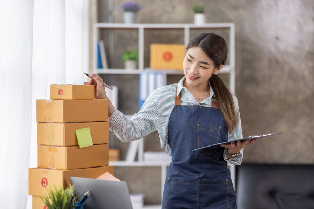 年轻的亚洲女性的肖像工作中小企业与一个盒子在家里的工作场所。创业小型企业业主，小型企业企业家中小企业或自由商业在线和交付的概念。图片下载