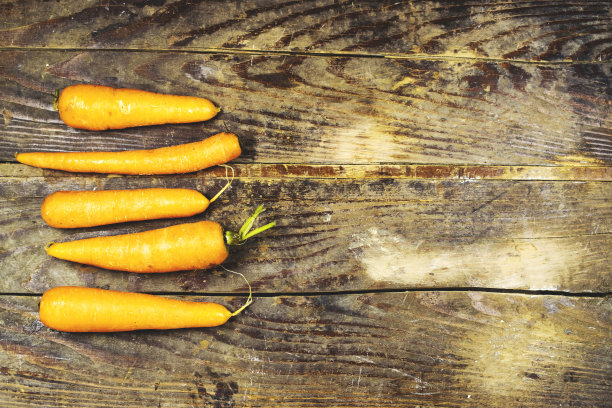 木头桌子上新鲜胡萝卜的复古照片图片下载