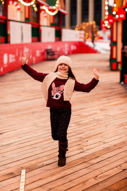 女孩跑过新年的小镇。她很快乐。圣诞节，新年，假期。新年的位置图片下载