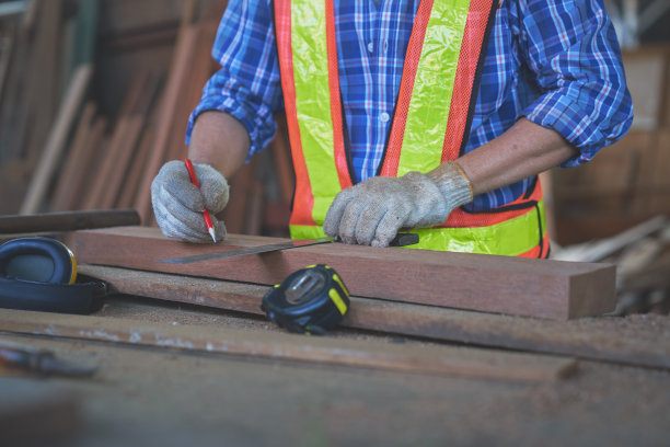 亚洲老人木匠工作计量木材之前，切割图片下载