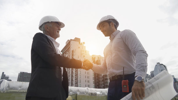 工程师或工人团队，在工业工厂工作的人。屋顶建筑上的冷却塔。系统工作的机器。冷凝器供水管路。通风式压缩机图片下载