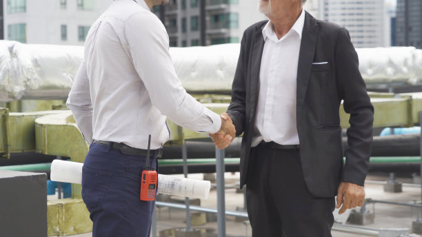 工程师或工人团队，在工业工厂工作的人。屋顶建筑上的冷却塔。系统工作的机器。冷凝器供水管路。通风式压缩机图片下载