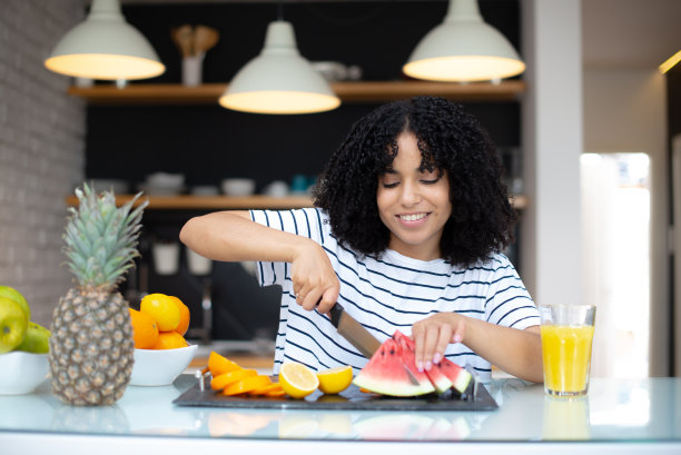 漂亮的年轻女人在厨房里吃早餐的照片图片下载