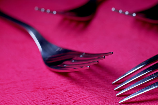 金属叉子在红色织物背景图片下载