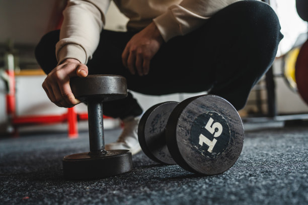 特写哑铃和手不明白人男子在健身房训练锻炼和健美概念图片下载
