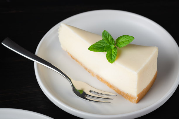 奶酪蛋糕放在黑色的木桌上图片下载