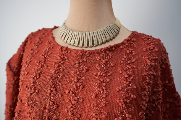 模特身上的橙色上衣和项链。妇女的正式的服装图片下载