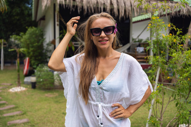 年轻的白人妇女在她的别墅前，在旅游胜地图片下载