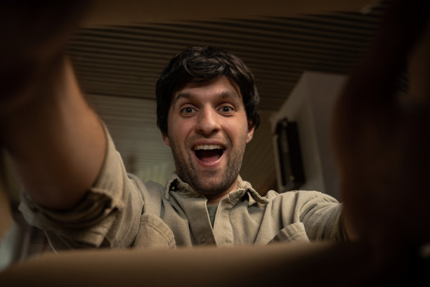 快乐而惊讶的男人打开了一个带着包裹的盒子。拆箱内部视图。图片下载