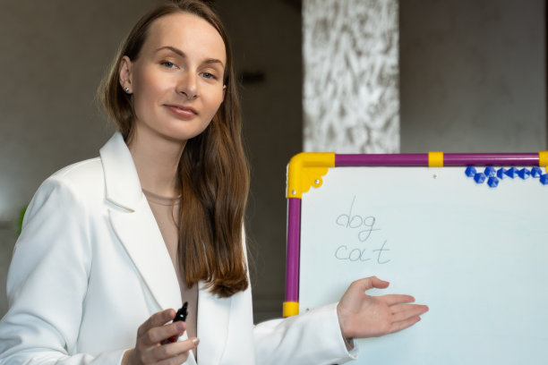 英语老师在线在家。一个女人在课堂上黑板上写字的肖像图片下载