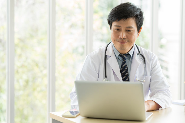 亚洲医生在医院的办公室里穿着带听诊器的制服。图片下载