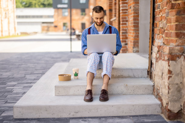时髦的家伙在街上用笔记本电脑工作图片下载